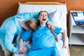 Woman giving birth in hospital while man hugging her Royalty Free Stock Photo