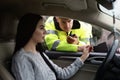 Woman giving bribe to police officer out of car window Royalty Free Stock Photo