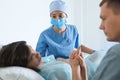 Woman giving child birth in maternity hospital, focus on midwife Royalty Free Stock Photo