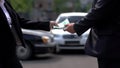 Woman giving euros to man on cars background, rent agreement, business deal Royalty Free Stock Photo