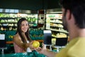 Woman giving fruit to cashier for billing at supermarket Royalty Free Stock Photo