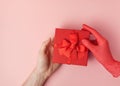 Woman giving a gift in a red cardboard box to a man with one hand Royalty Free Stock Photo