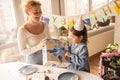 Woman giving a gift to her daughter wearing party cap while spending her birthday Royalty Free Stock Photo