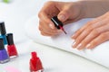 Woman giving herself elegant manicure at home