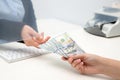 Woman giving money to teller at cash department window Royalty Free Stock Photo