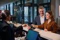 Woman giving passport to female european receptionist near man in hotel Royalty Free Stock Photo