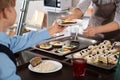 Woman giving plate with healthy food to boy in school canteen Royalty Free Stock Photo