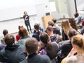 Woman giving presentation in lecture hall at university. Royalty Free Stock Photo