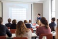 Woman giving presentation in lecture hall at university. Royalty Free Stock Photo