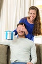 Woman giving a surprise gift to her man Royalty Free Stock Photo