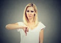 Woman giving thumb down gesture looking with negative expression and disapproval Royalty Free Stock Photo