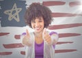 Woman giving two thumbs up against hand drawn american flag and white wall with flare Royalty Free Stock Photo