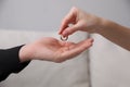 Woman giving wedding ring to her husband indoors, closeup. Divorce concept Royalty Free Stock Photo