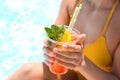 Woman with glass of drink near swimming pool, closeup Royalty Free Stock Photo