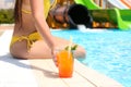 Woman with glass of drink near swimming pool, closeup Royalty Free Stock Photo