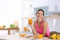 Woman with glass of orange juice at table in kitchen Royalty Free Stock Photo