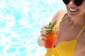 Woman with glass of refreshing drink near swimming pool Royalty Free Stock Photo