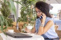 Woman in glass working remotely with laptop and phone in cafe. Beautiful brunette using notebook in cafe. Happy businesswoman Royalty Free Stock Photo