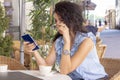 Woman in glass working remotely with laptop and phone in cafe. Beautiful brunette using notebook in cafe. Happy businesswoman call Royalty Free Stock Photo