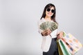 Woman with glasses confident shopper smile holding online shopping bags multicolor and dollar money banknotes on hand Royalty Free Stock Photo