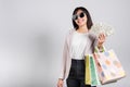 Woman with glasses confident shopper smile holding online shopping bags multicolor and dollar money banknotes on hand Royalty Free Stock Photo