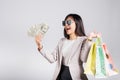 Woman with glasses confident shopper smile holding online shopping bags multicolor and dollar money banknotes on hand Royalty Free Stock Photo