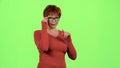 Woman in glasses flirts and winks with the men. Green screen