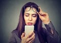 Woman with glasses having trouble seeing cell phone has vision problems. Royalty Free Stock Photo