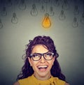 Woman in glasses looking up at idea light bulb above head Royalty Free Stock Photo