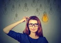 Woman in glasses looking up light idea bulb above head Royalty Free Stock Photo