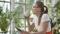 Woman in glasses and ponytail surfs internet drinking coffee Royalty Free Stock Photo