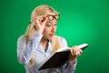 Woman with glasses reading looking at book shocked surprised Royalty Free Stock Photo