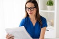 Woman in glasses reading newspaper at office Royalty Free Stock Photo