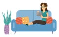 Woman in glasses sitting on the couch with a tablet. The girl with electronic equipment playing game Royalty Free Stock Photo