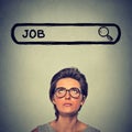 Woman in glasses thinking looking for a new job isolated on gray wall background Royalty Free Stock Photo