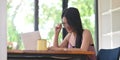 A woman with glasses is using a computer laptop while sitting at the wooden working desk Royalty Free Stock Photo