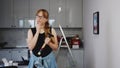 woman with glasses wearing a black sleevless shirt and holding a hammer, thinking about repair