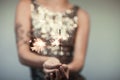 Woman in glitter dress holding sparkler, close up hands, romantic look