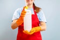 Woman in glove holding a plastic detergent bottle on blue background Royalty Free Stock Photo