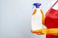 Woman in glove holding a plastic detergent bottle on blue background Royalty Free Stock Photo