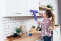 Woman in gloves cleaning cabinet with rag at home kitchen. Royalty Free Stock Photo