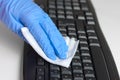 Woman with gloves cleaning and disinfecting computer keyboard with napkins Corona virus cleaning and disinfection of your