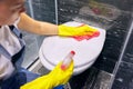 Woman in gloves with detergent washing the toilet close-up