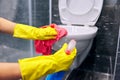 Woman in gloves with detergent washing the toilet close-up