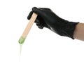 Woman in gloves holding spatula with hot depilatory wax on white background, closeup