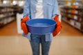 Woman in gloves holds bowl, houseware store