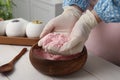 Woman in gloves making bath bomb mixture at white table indoors, closeup Royalty Free Stock Photo