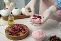 Woman in gloves making bath bomb at white table indoors, closeup Royalty Free Stock Photo