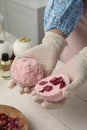 Woman in gloves making bath bomb at white table indoors, closeup Royalty Free Stock Photo