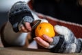 A woman with gloves peels an orange Royalty Free Stock Photo